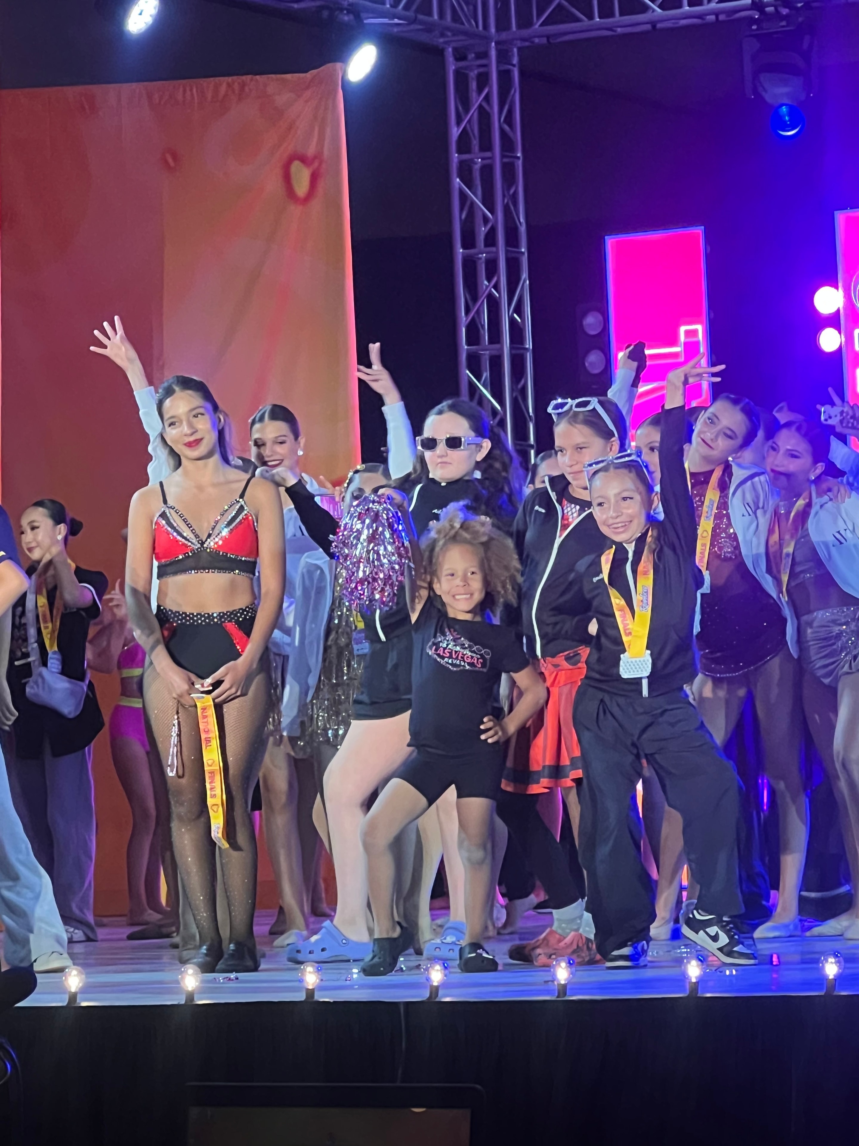 KPAC competition team on stage under neon lights
