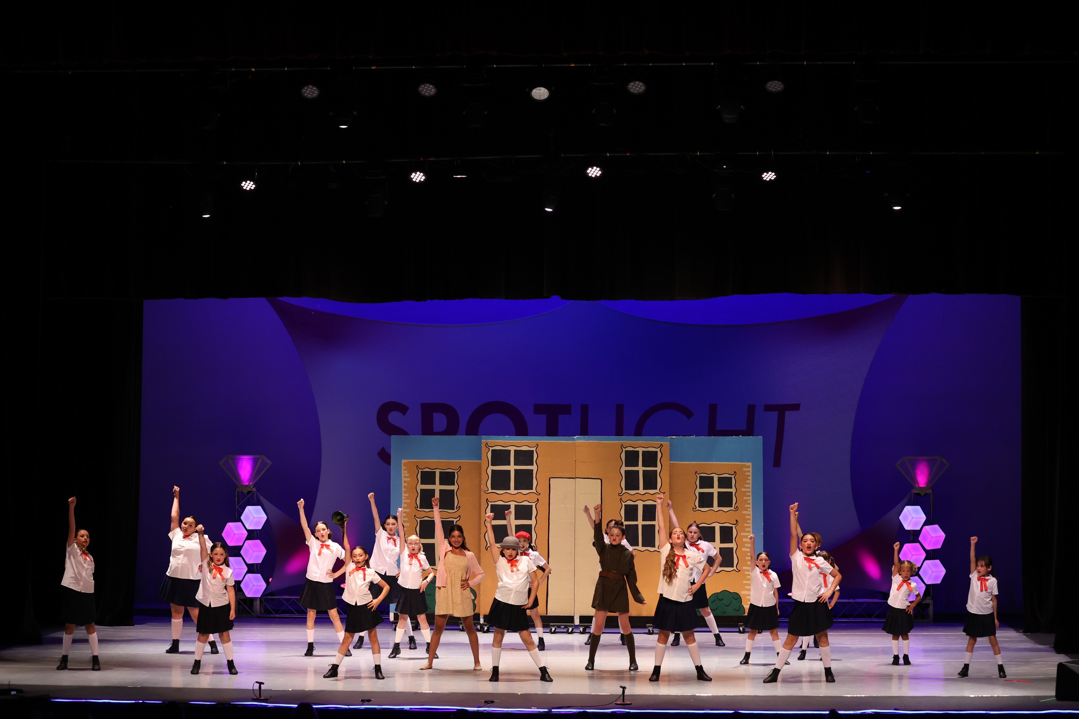 KPAC competition team on stage with fists raised at Spotlight