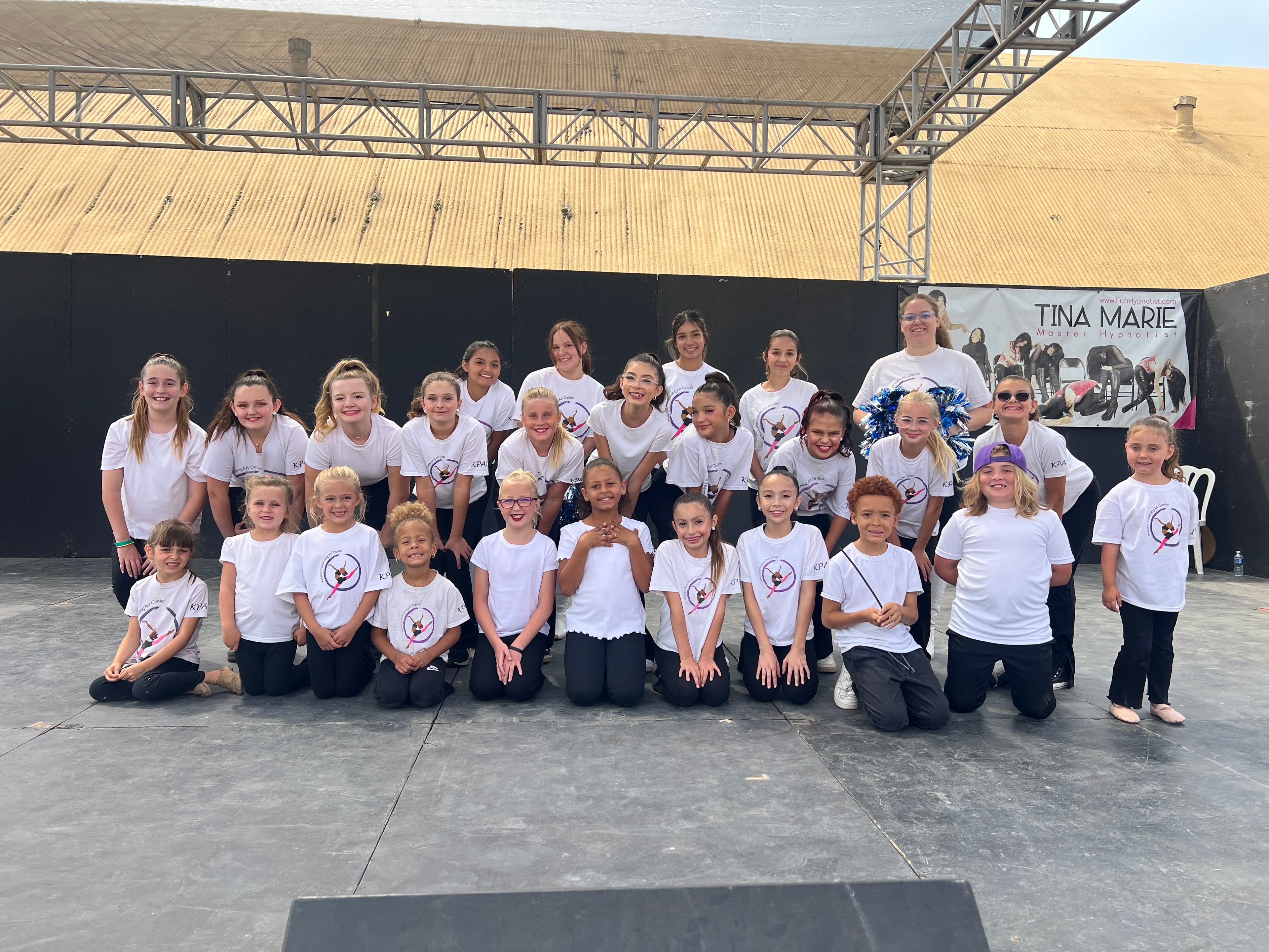 KPAC dancers in matching shirts posing together at a fair
