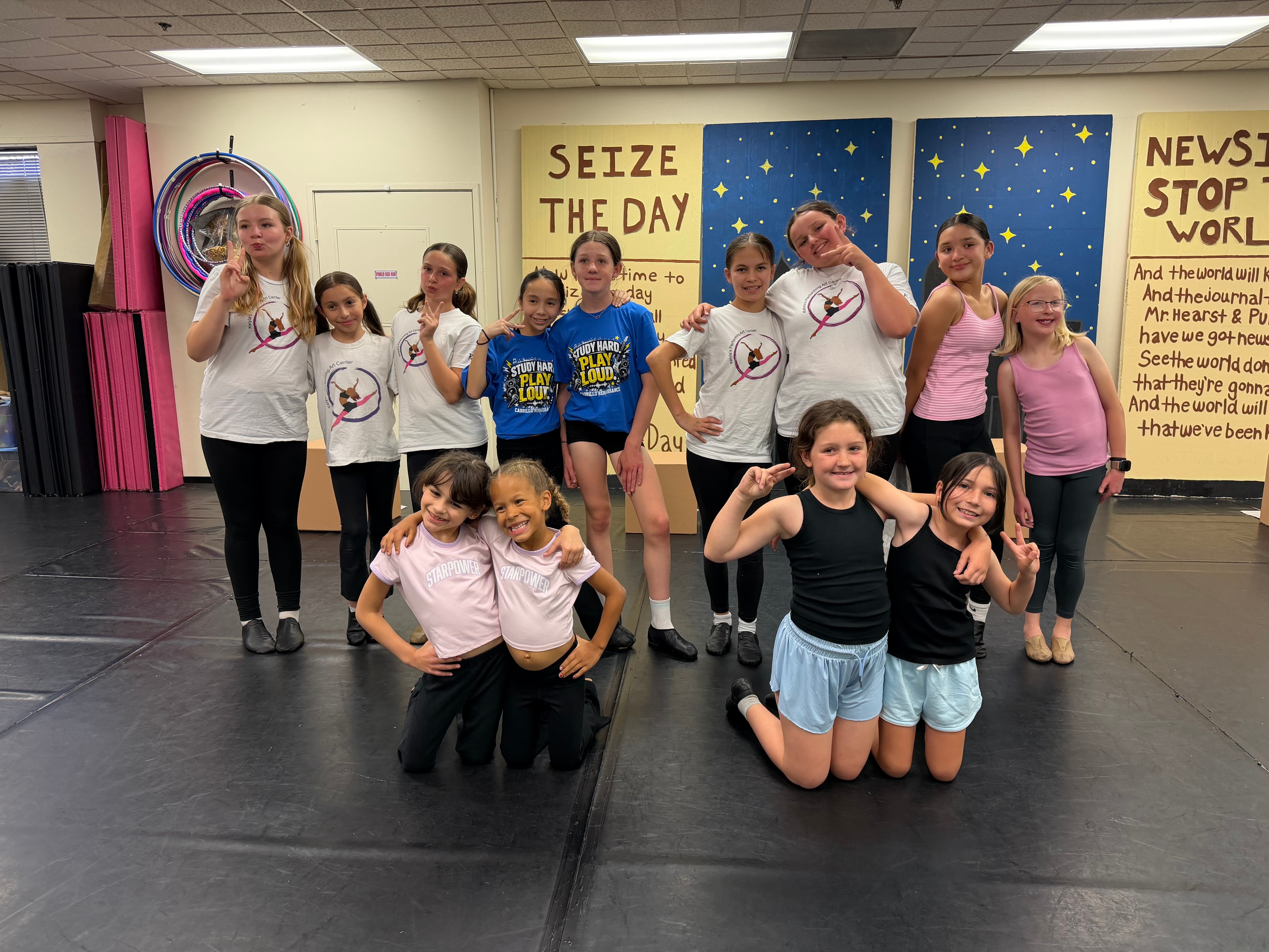 KPAC dancers goofing off in front of the Newsies set pieces during rehearsal