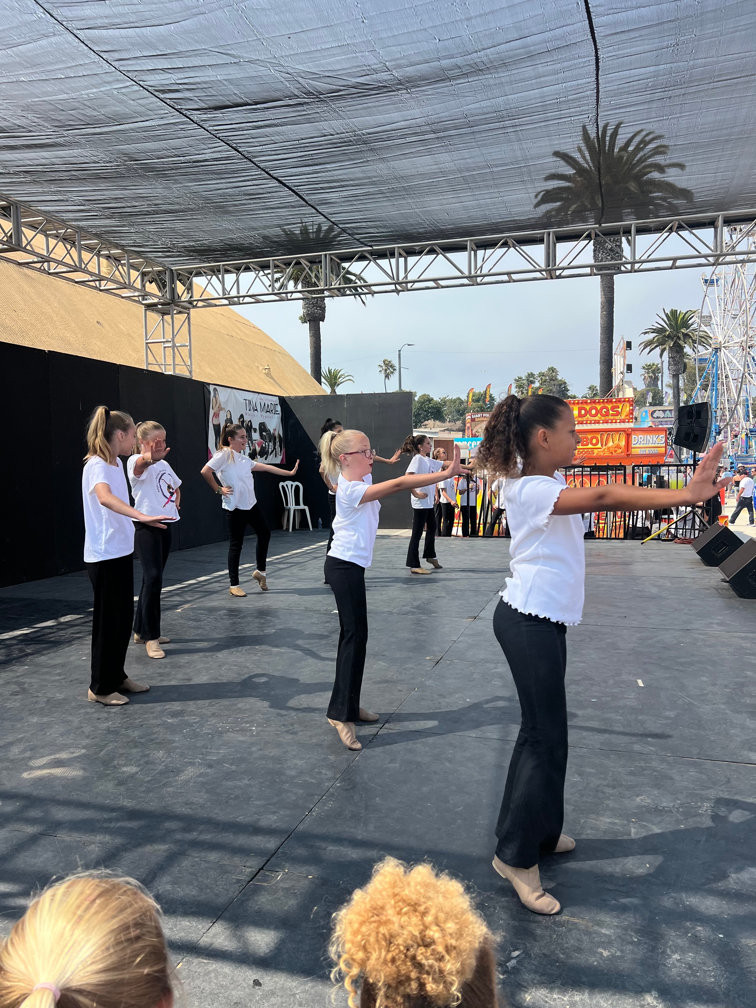 KPAC dancers performing on an outdoor stage at a fair