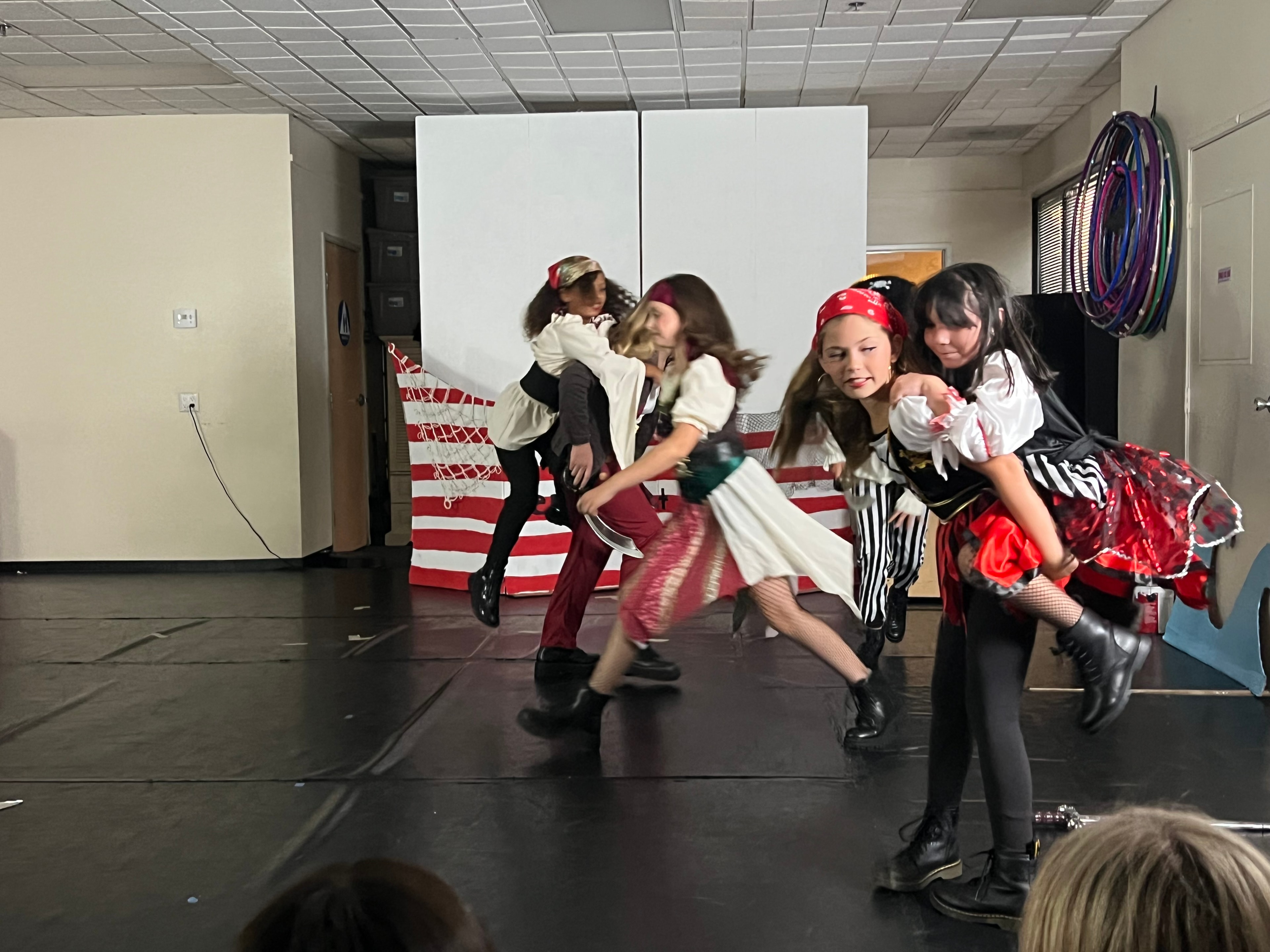 Dancers in pirate costumes in action on stage