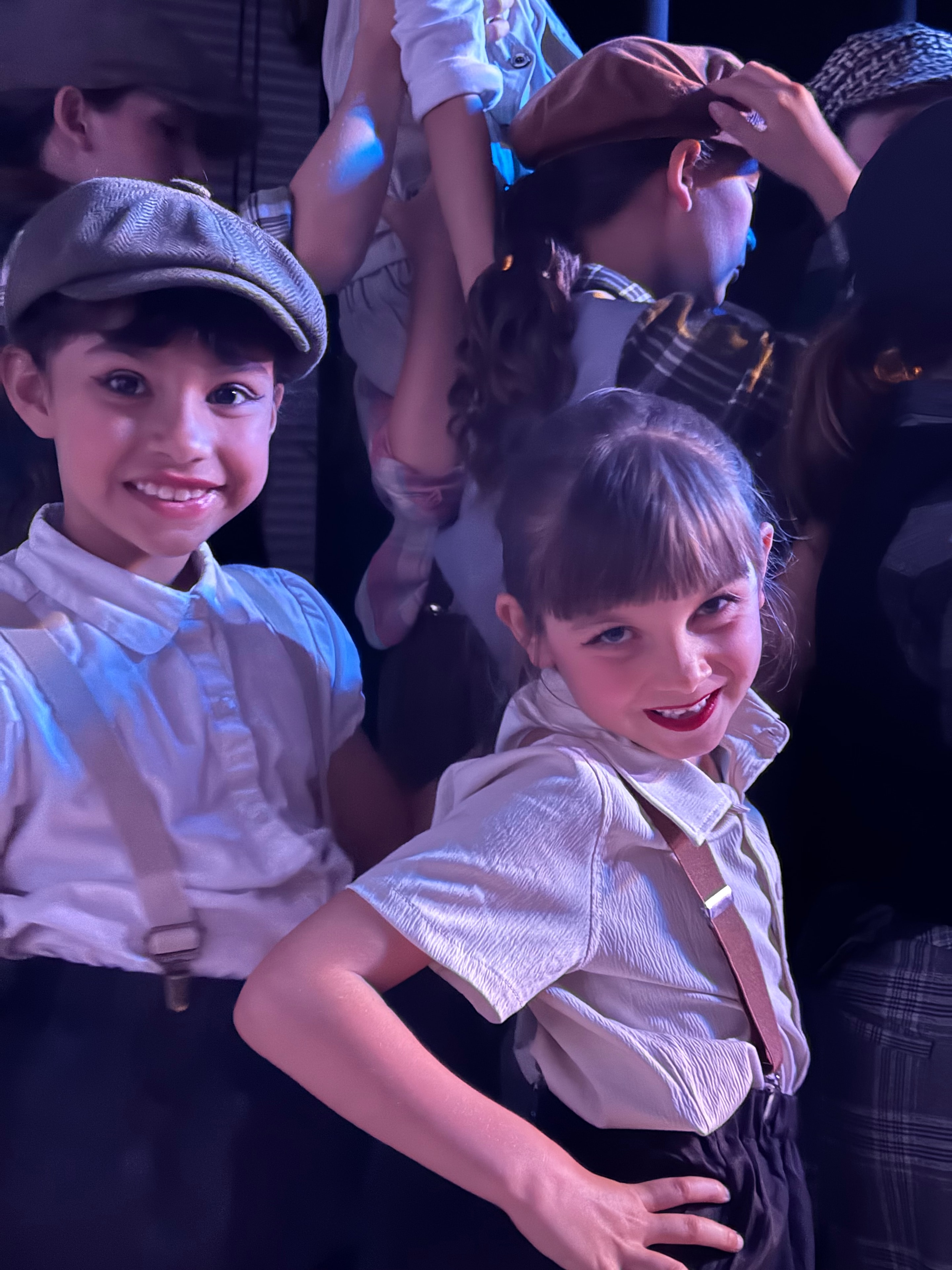 Young KPAC performers smiling in Newsies costumes