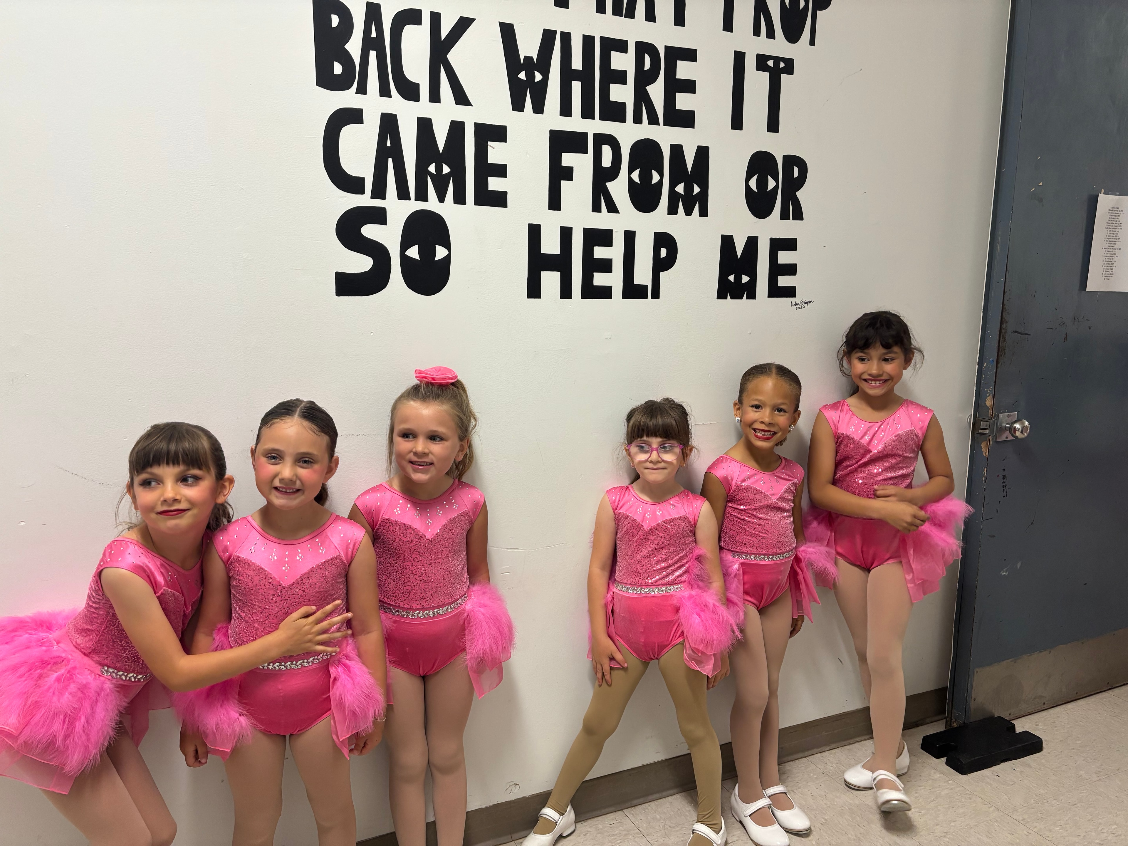 Dancers in pink costumes backstage at recital