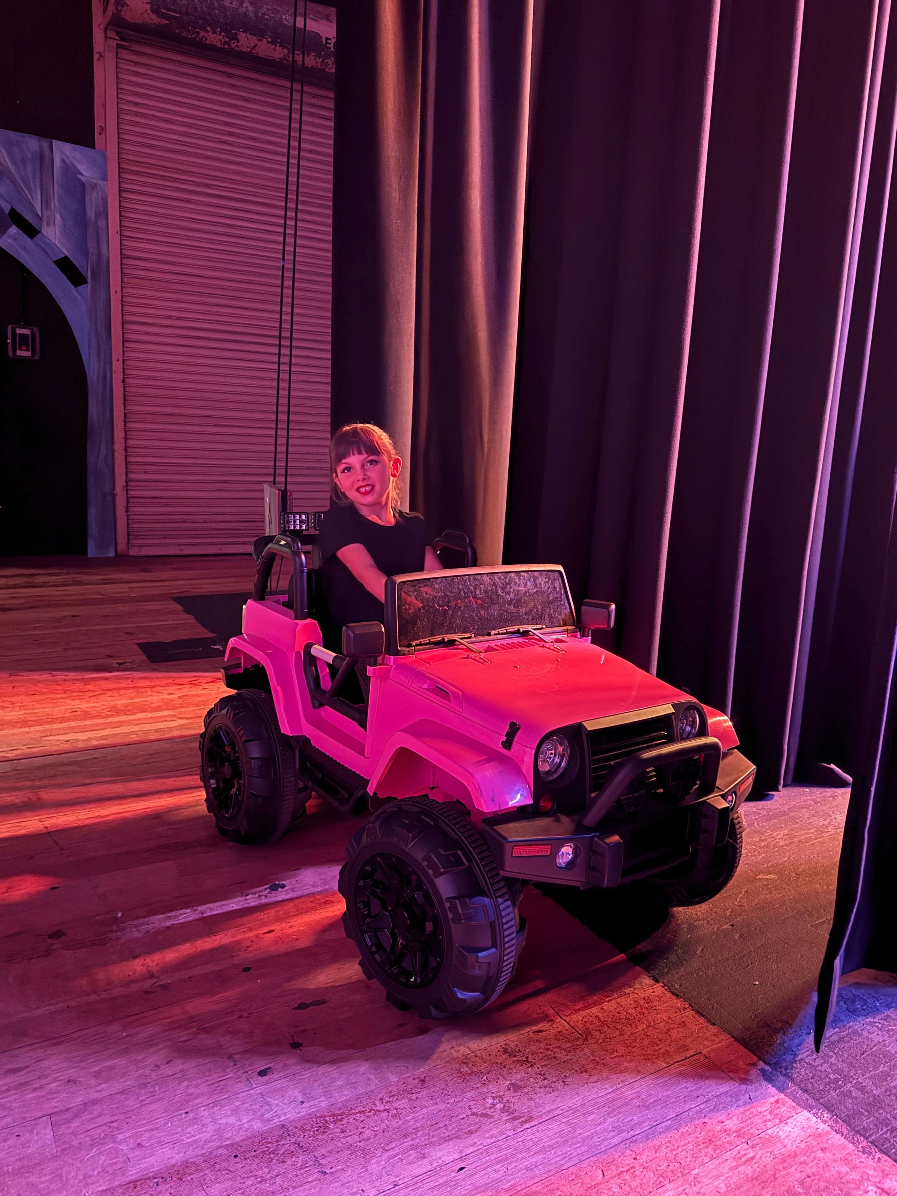 Young dancer on stage with pink Jeep prop